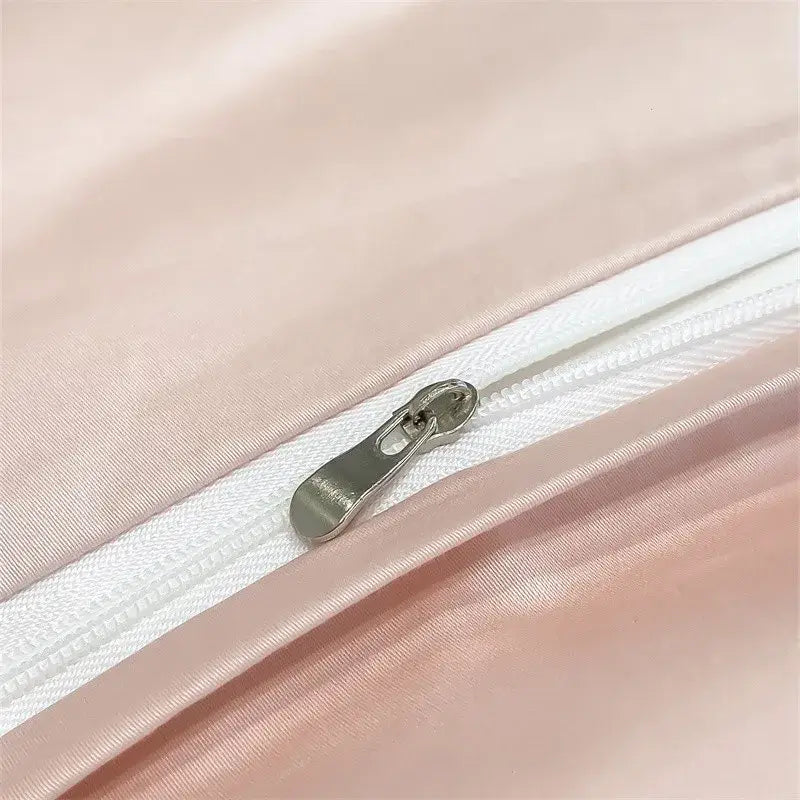 A sleek silver zipper with a metallic pull tab on a soft pink satin decorbites™ duvet cover made from 1000TC cotton
