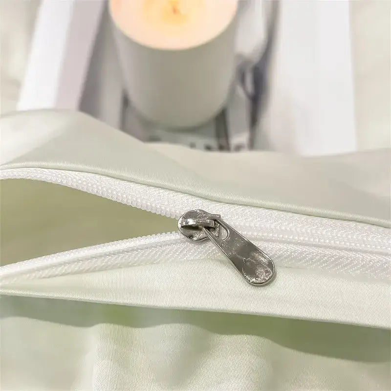 A sleek silver zipper on a pale green satin fabric piece duvet cover from decorbites™ luxurious 1000tc egyptian cotton bedding set