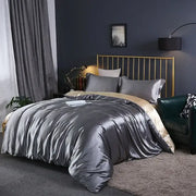 DecorBites™ luxurious bedding set featuring a metallic gray satin duvet cover with subtle gold inner lining draped on bed
