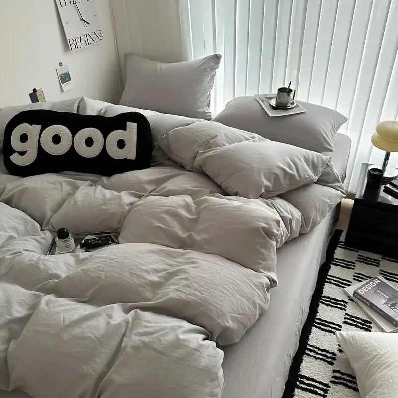 Black knit pillow with white embroidered good lettering paired with DecorBites cotton bedding set for luxe comfort
