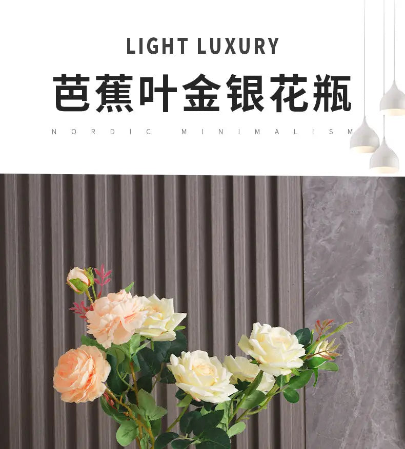 A delicate arrangement of artificial roses in peach and cream hues with green leaves in decorbites™ luxurious gold ceramic vases for home decor