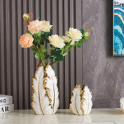 White ceramic vase with gold leaf detailing shaped like a feather from DecorBites™ luxurious gold ceramic vases for home decor