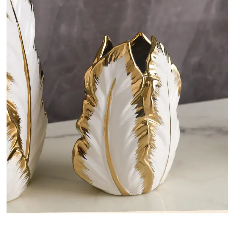 White ceramic vase with gold leaf detailing shaped like a stylized tulip for luxurious gold ceramic vases home decor