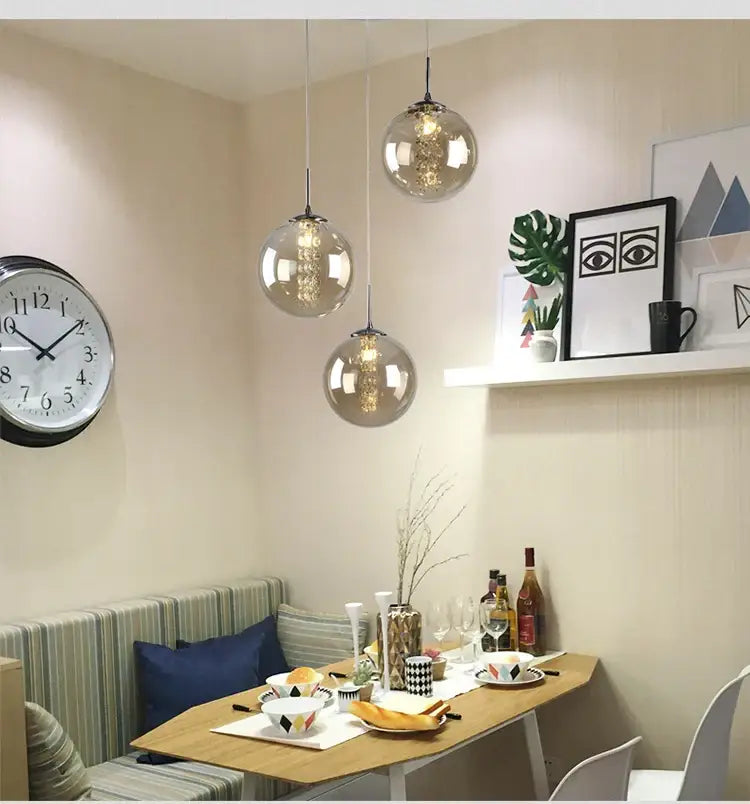 Three spherical glass pendant lights with warm filament bulbs in decorbites™ luxurious spiral led chandelier for home and hotel