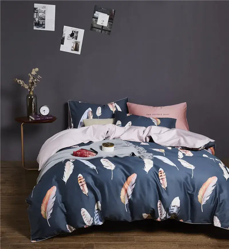 Navy blue feather-print duvet cover set with coordinating pink and beige pillowcases made of egyptian cotton