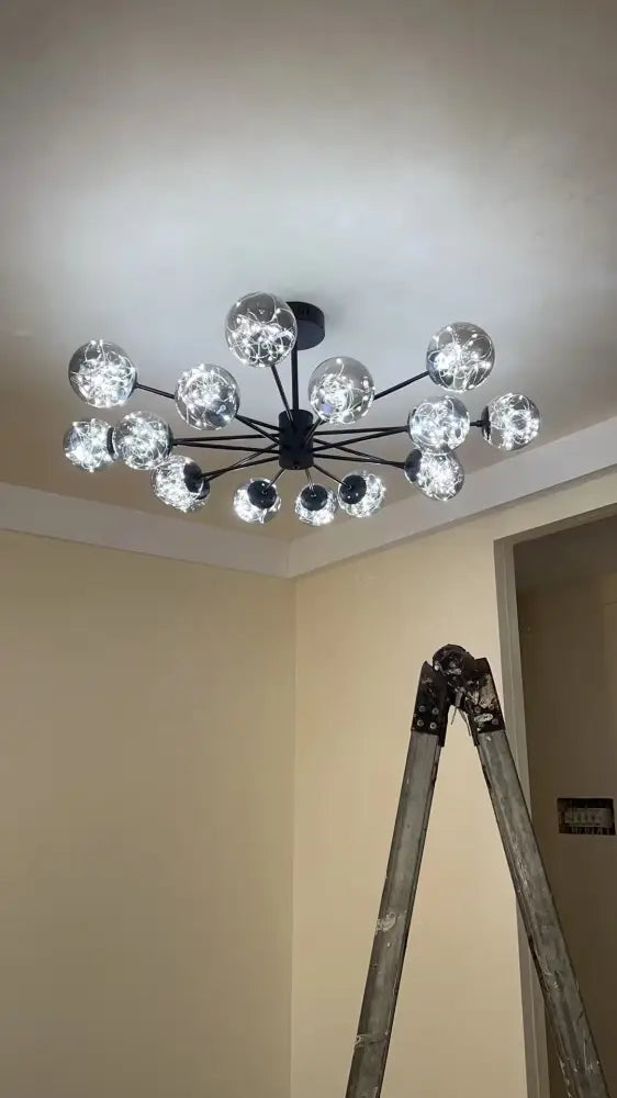 Modern black metal chandelier with multiple clear glass ball bulbs emitting warm light and dimmable via remote control