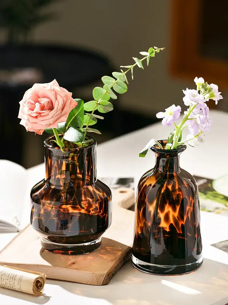 Two amber tortoiseshell luxury leopard glass vases with fresh flowers for elegant home decor accents