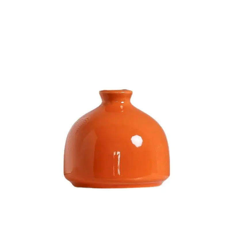 A glossy orange luxury modern ceramic vase with a rounded bulbous body and narrow neck by decorbites