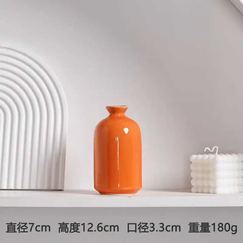 A glossy orange luxury modern ceramic vase with a rounded body and narrow neck for elegant decor
