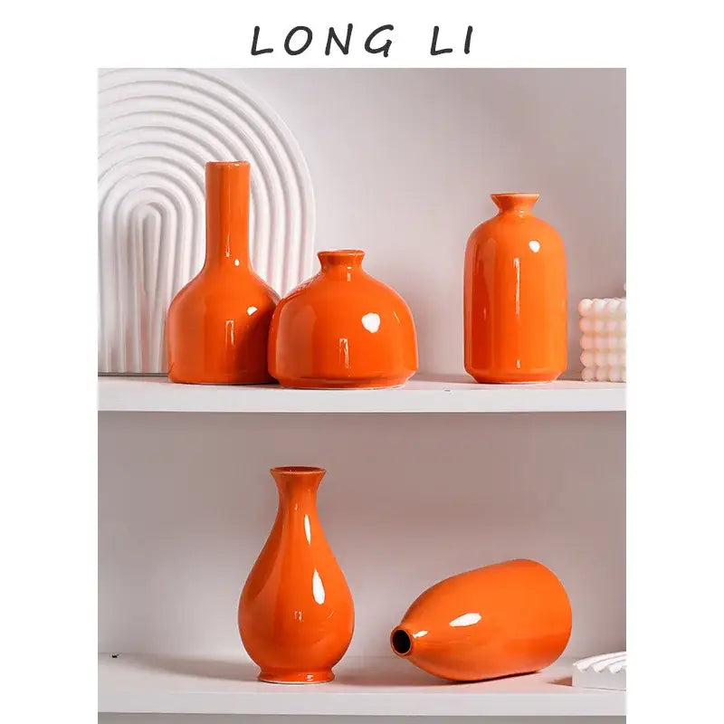 Set of five vibrant orange luxury modern ceramic vases with glossy finishes displayed on white shelves
