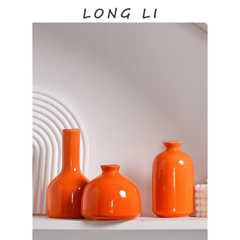 Set of three vibrant orange luxury modern ceramic vases with glossy finishes and distinct shapes from decorbites