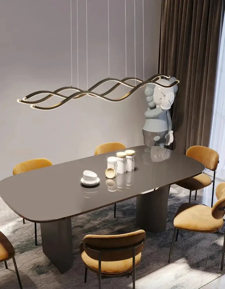 Modern gold-toned wave-shaped luxury nordic chandeliers pendant light hanging above dining room table by decorbites