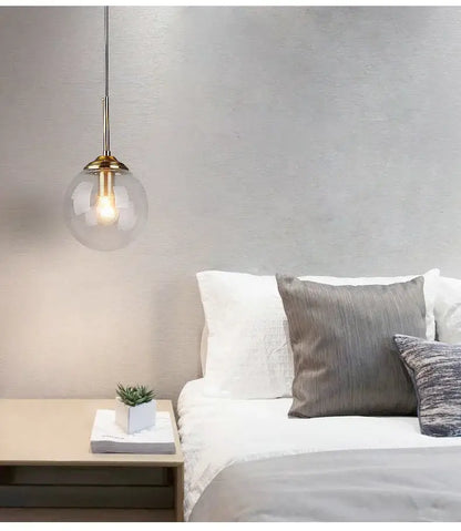 Decorbites luxury nordic led chandelier with clear glass globe and brass fixture hanging above bed for dining room use
