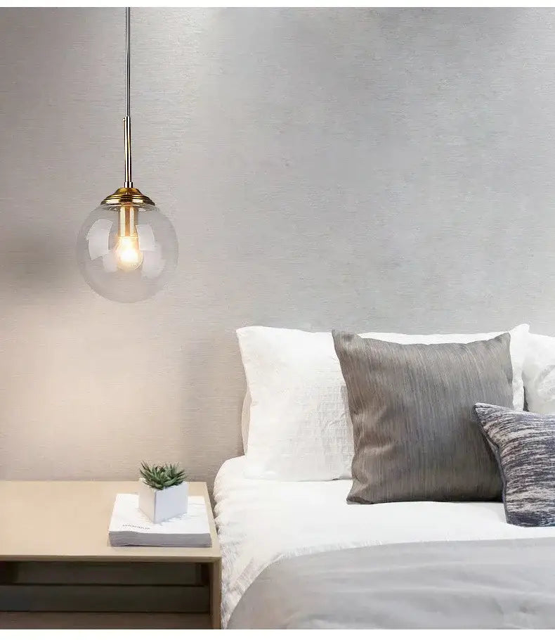 Decorbites luxury nordic led chandelier with clear glass globe and brass fixture hanging above bed for dining room use