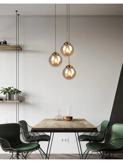 Three spherical glass pendant lights with brass fixtures in the decorbites luxury nordic led chandelier for dining room