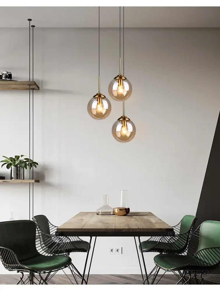Three spherical glass pendant lights with brass fixtures in the decorbites luxury nordic led chandelier for dining room