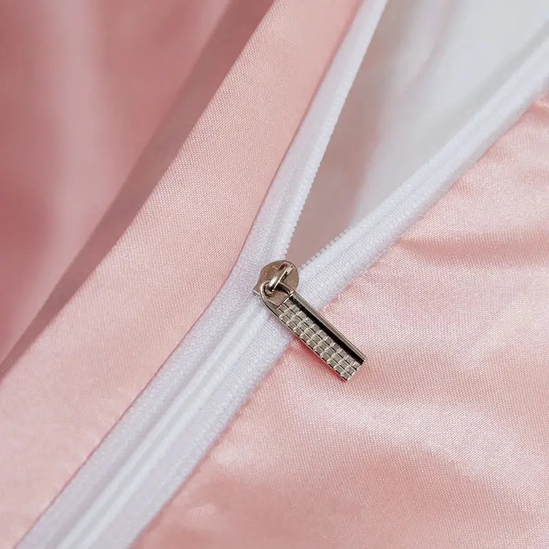 Silver-toned zipper pull with textured grid pattern on soft pink rayon satin pcduvet cover from DecorBites luxury bedding set