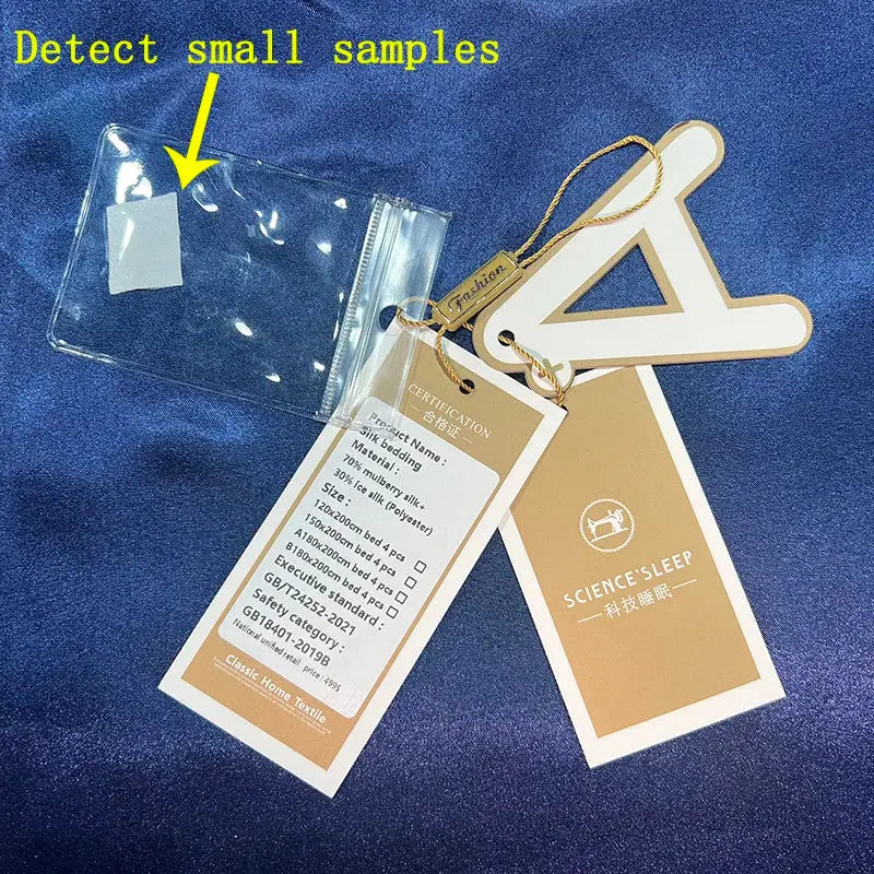 Clear plastic sample pouch with white label attached to beige and gold science sleep tags on luxury silk bedding set