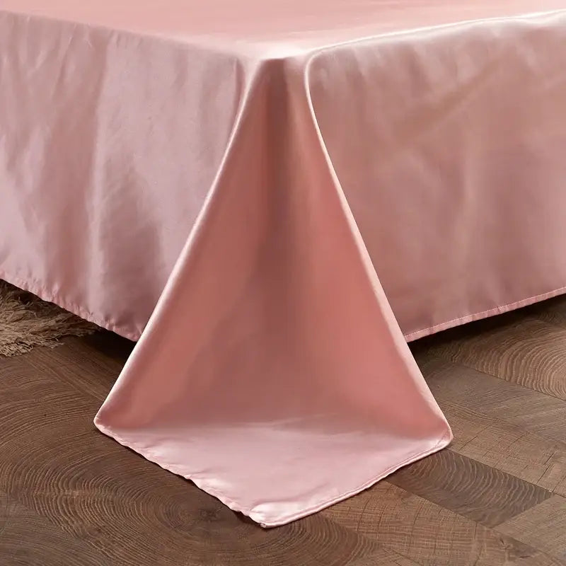 A soft blush pink satin bed skirt with a glossy finish drapes over the edge in the DecorBites Luxury solid color bedding set
