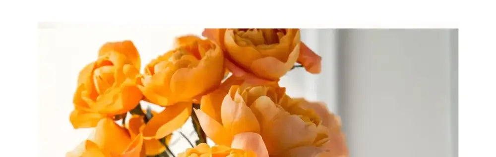 A bouquet of vibrant orange roses in a decorbites™ luxury stainless steel vase for elegant home decor display
