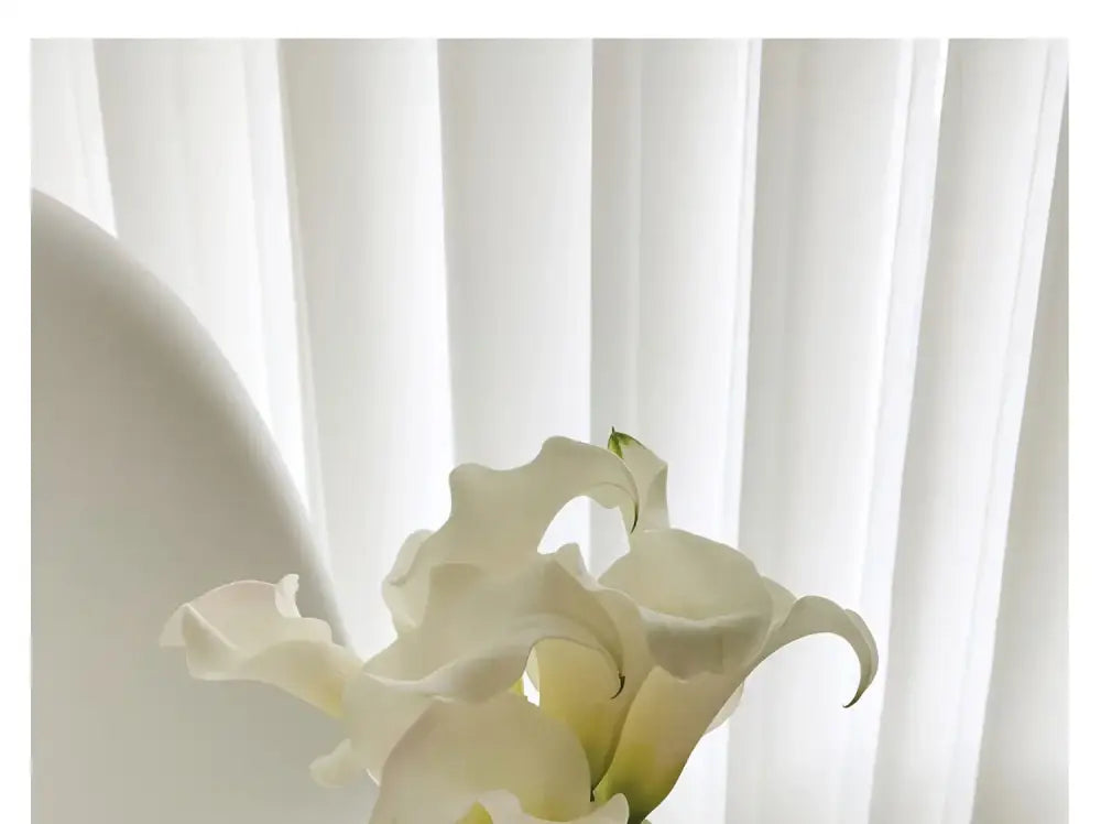 A delicate bouquet of white calla lilies in a luxury stainless steel vase by decorbites for elegant home decor