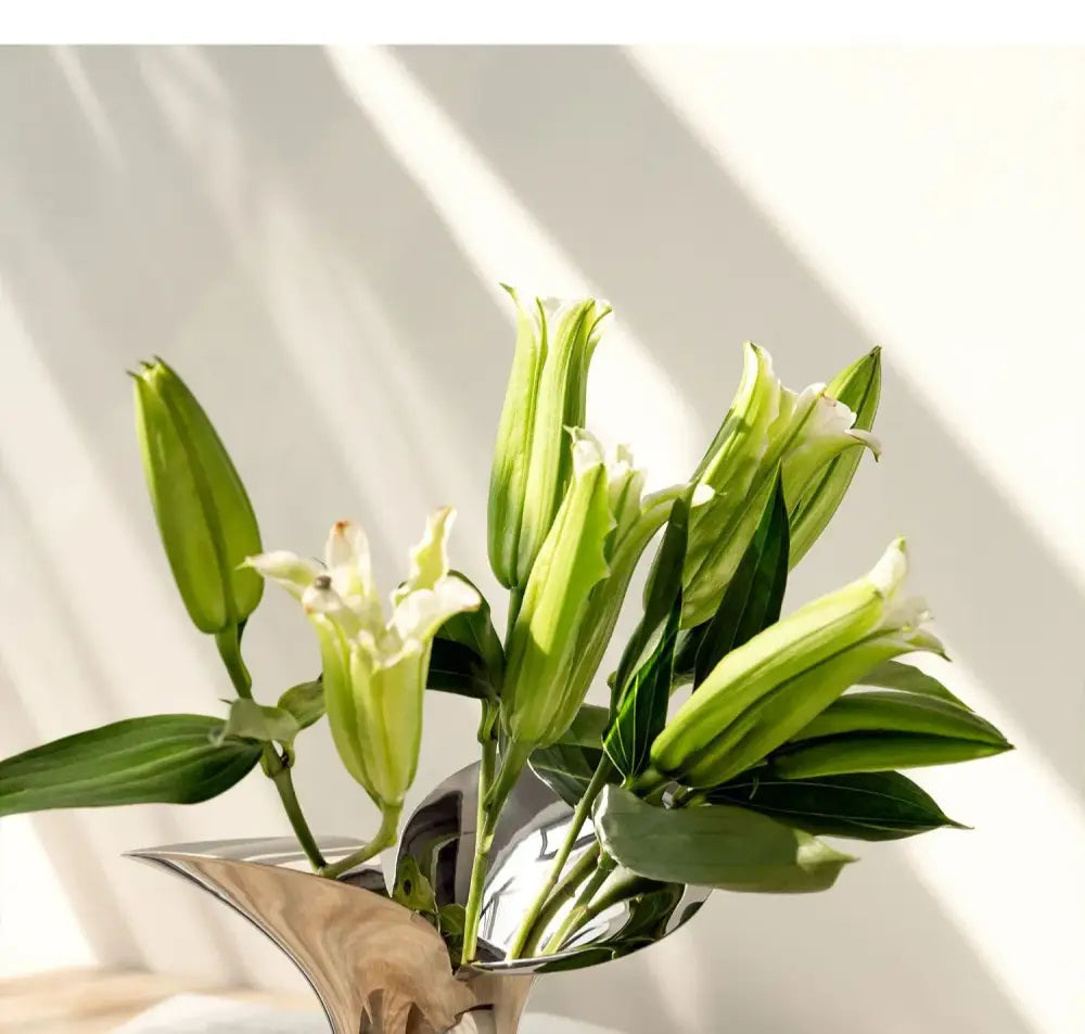DecorBites™ luxury stainless steel vase in metallic silver holds white lilies and green buds for home decor