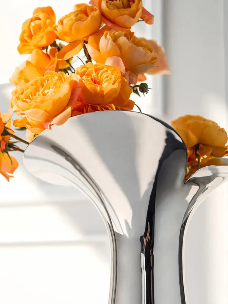 Decorbites luxury stainless steel vase with sleek silver-toned design holding vibrant orange roses for home decor