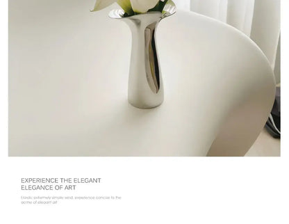 Decorbites luxury stainless steel vase in sleek silver metallic with modern sculptural design holding white flowers