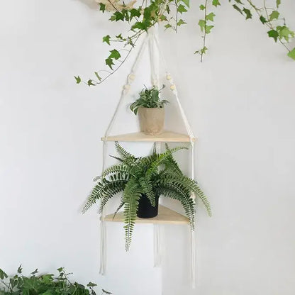 DecorBites macrame wall hanging corner shelf with two light wood tiers and white cord holding green plants