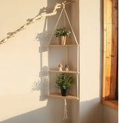Beige DecorBites™ macrame wall hanging corner shelf with three wooden tiers and tassel for boho decor