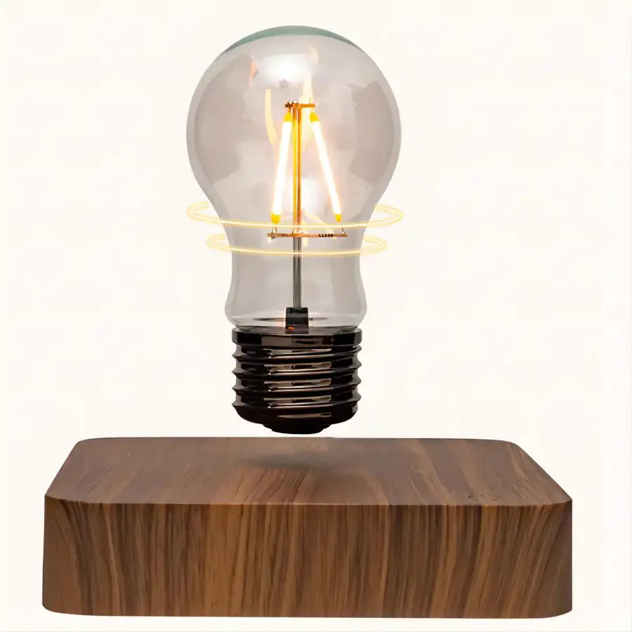 Floating transparent glass led bulb with warm filament levitating above wooden base magnetic levitation lamp