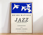 Blue and cream framed poster with stylized white birds and bold black text showcasing matisse floral art prints