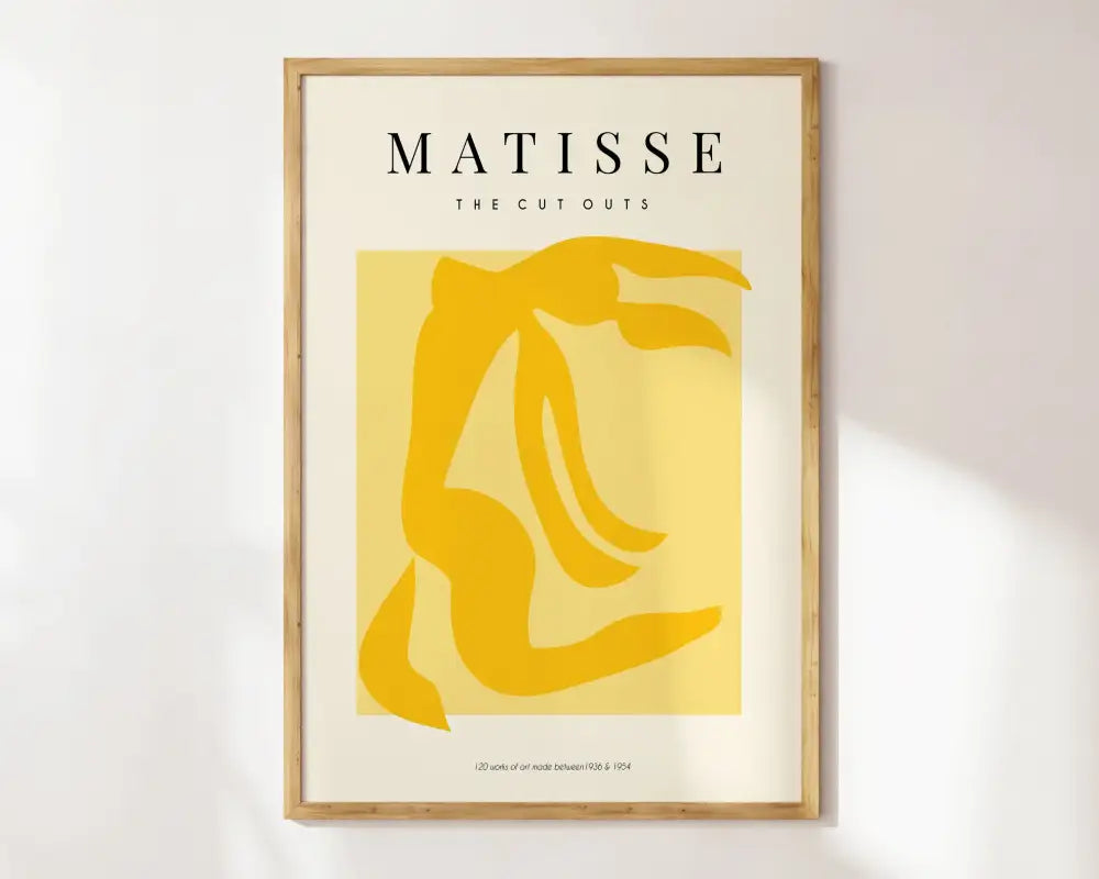 A minimalist framed decorbites™ matisse floral art print with a bold yellow abstract figure in a light wood frame