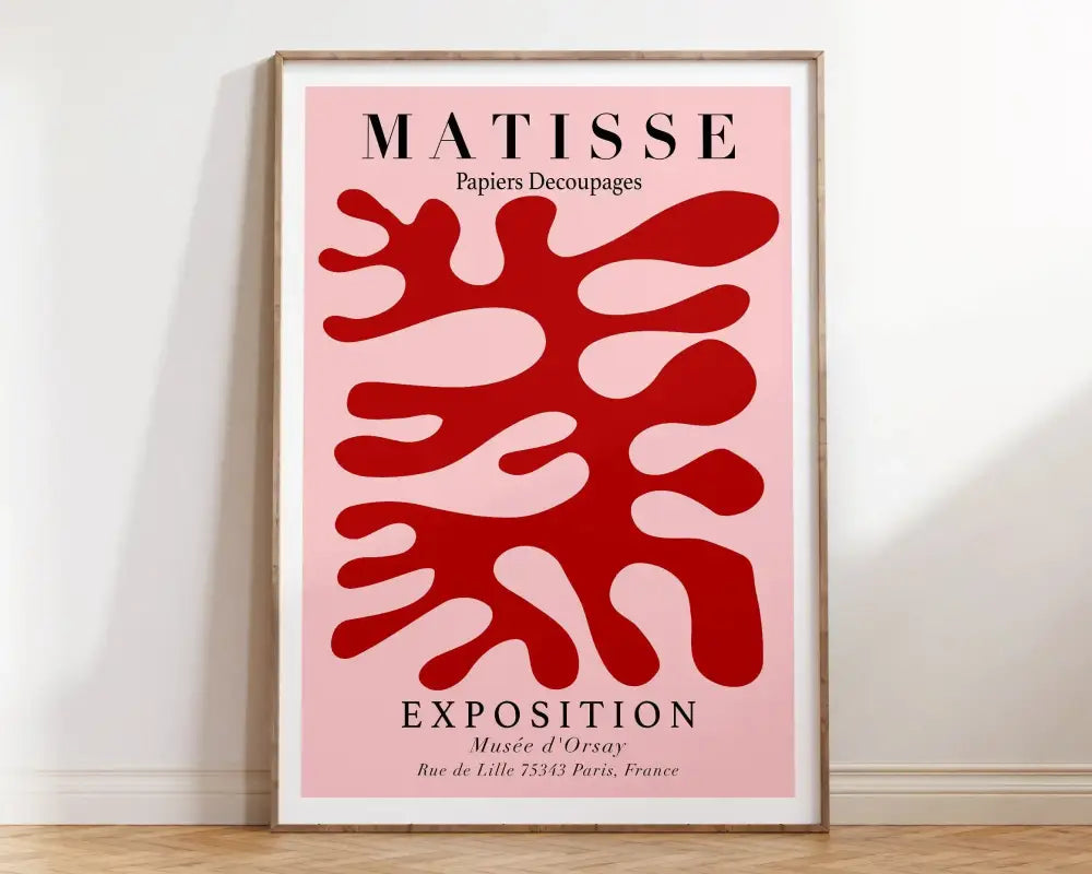 A framed decorbites™ matisse floral art print with bold red abstract flowers on a soft pink background in a wooden frame