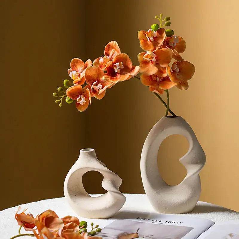Cream-colored cream-colored ceramic vase set with matte finish and abstract cut-out designs for modern home decor