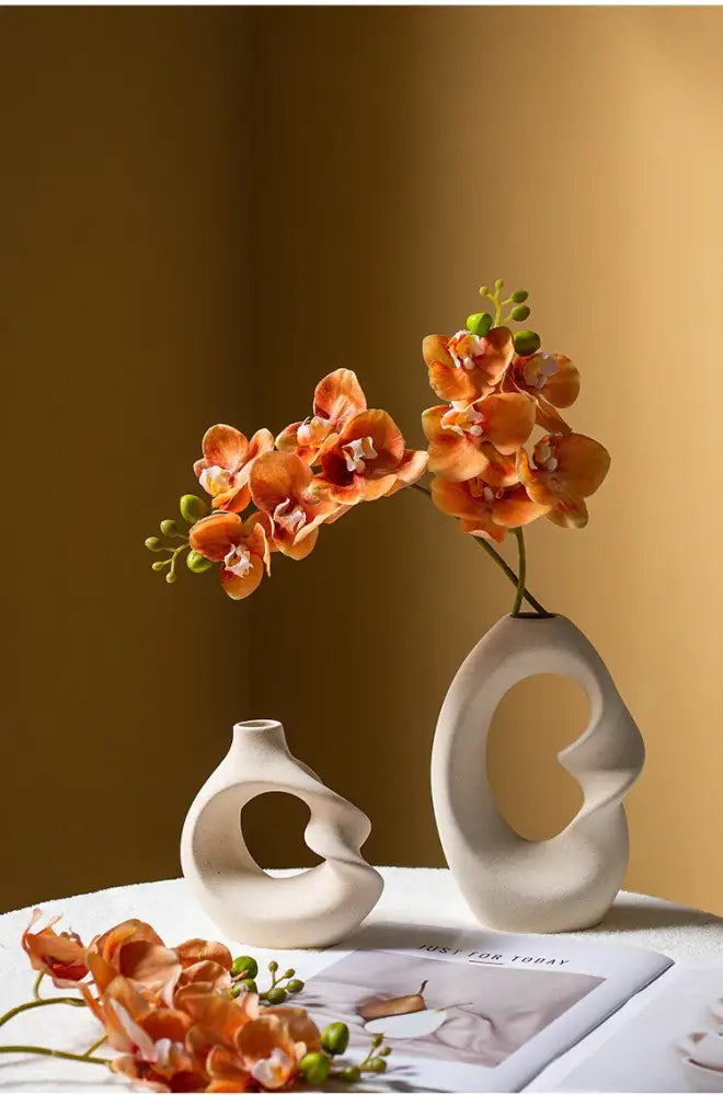 Cream-colored matte ceramic vase set with abstract cut-out designs for modern home decor by decorbites