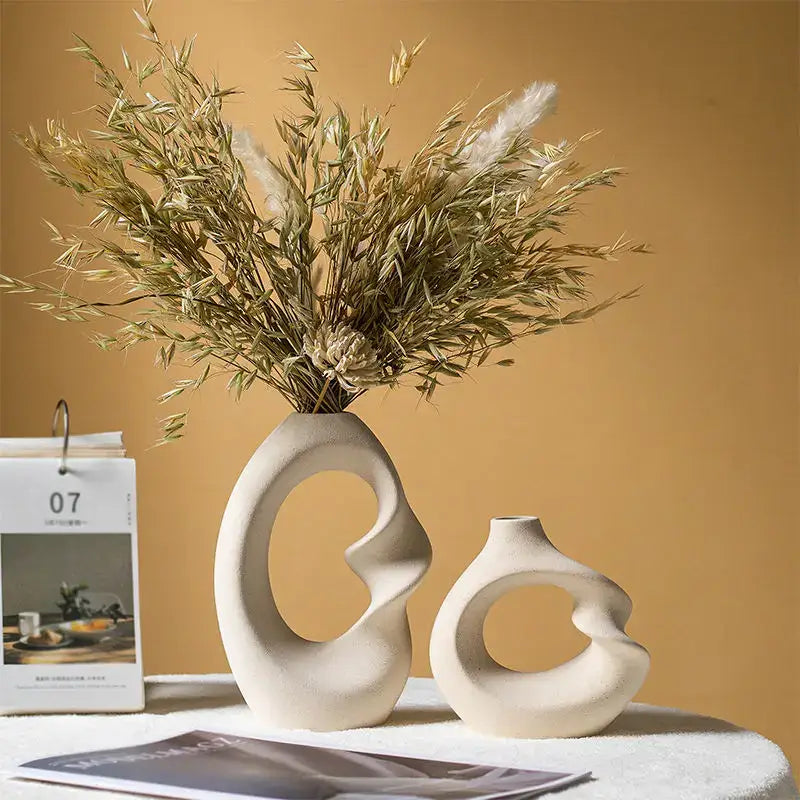 Cream-colored matte ceramic vase with sculptural curves and central cutout in DecorBites™ vase set for home decor