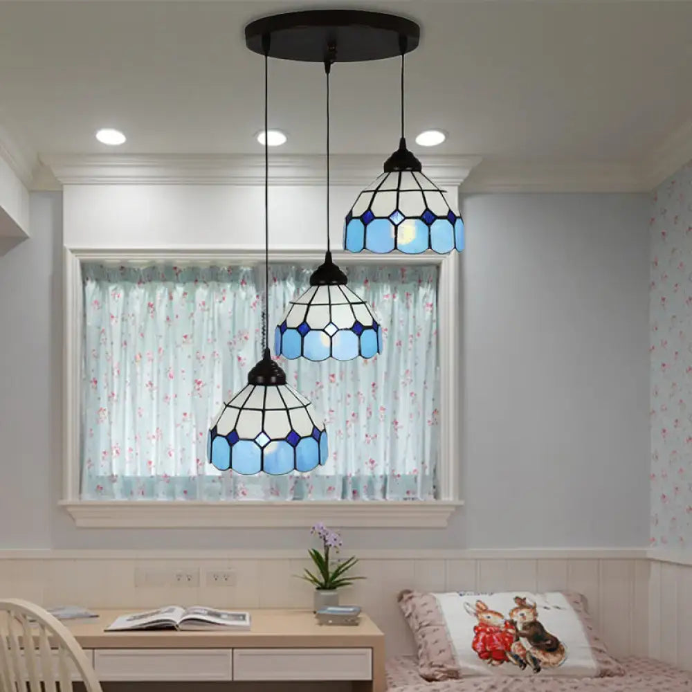 Three blue and white mediterranean cut glass bowl hanging light pendants with black metal frames on ceiling fixture