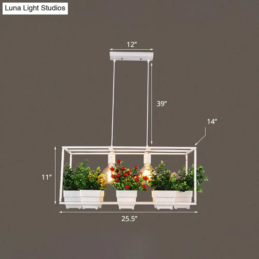 White metal rectangular light fixture with three exposed bulbs and artificial bonsai in white planters with fixture width