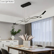 Modern black and white metal LED pendant light fixture with sleek wavy design for dining room island by DecorBites