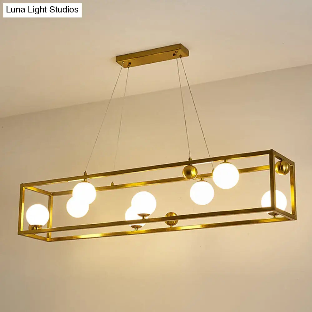 Gold-toned metal pendant light with milk glass shade and rectangular frame for industrial dining rooms by decorbites