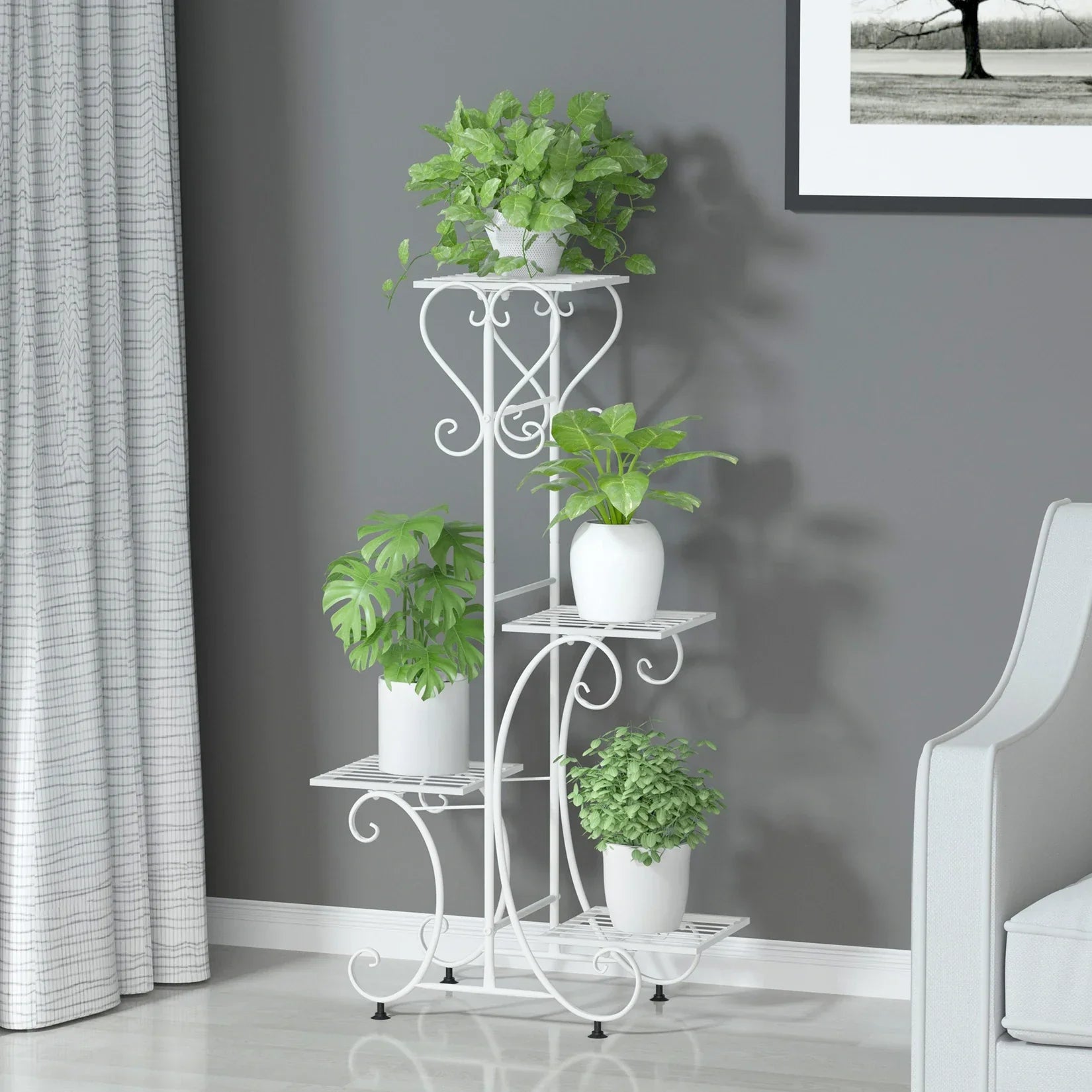 White wrought iron metal plant stand with ornate scrollwork and four tiers for holding four flower pots by DecorBites
