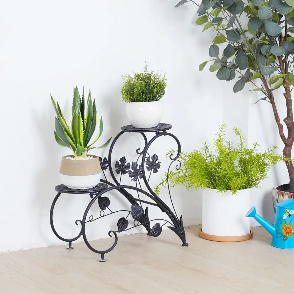 Black wrought iron metal plant stand with ornate leaf and vine designs for four potted flowers by decorbites