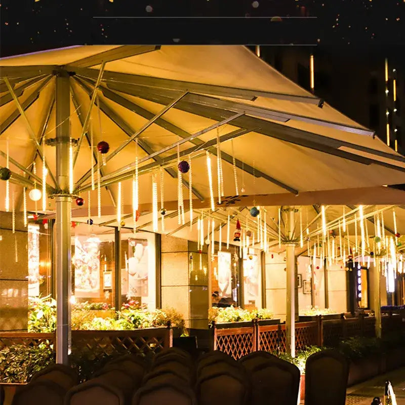 Beige canopy patio umbrella with metallic frame adorned by decorbites™ meteor shower led string lights for outdoor decor