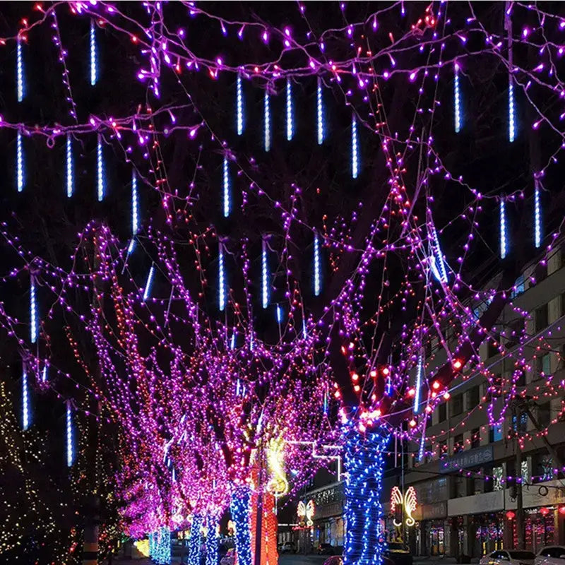 Purple and blue led string lights from decorbites meteor shower hang on tree branches for outdoor festive decor