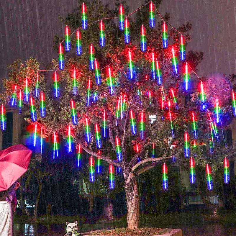 Rainy night tree decorated with DecorBites meteor shower led string lights in red green and blue for outdoor decor