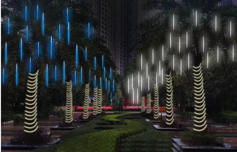 Rows of palm trees illuminated at night with DecorBites™ meteor shower led string lights in blue white and warm-white