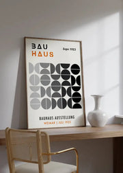 A minimalist framed decorbites mid century geometric canvas art with black gray white circles and bold orange bauhaus text