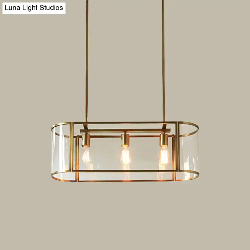 Brass-framed mid century pendant light with translucent glass panels and three exposed filament bulbs in a rectangular design