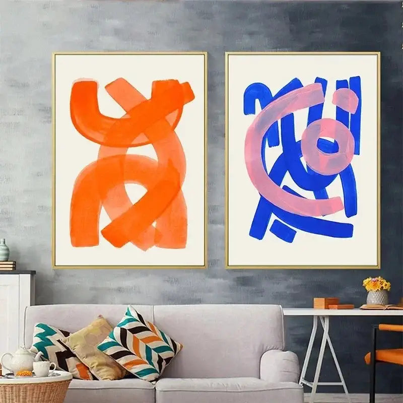 Two decorbites mid century canvas prints featuring bold orange and blue watercolor brush strokes on cream backgrounds framed gold
